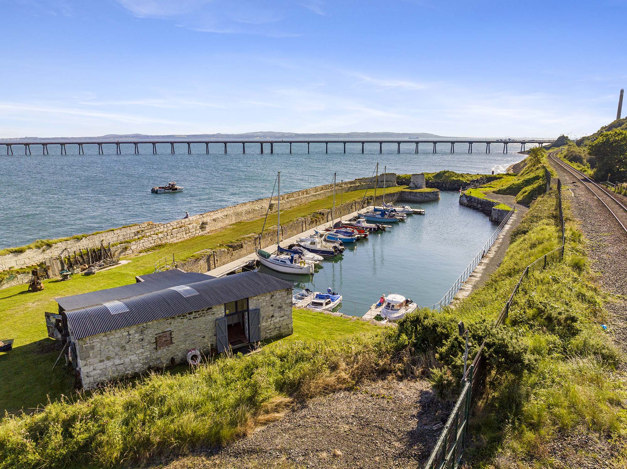 Whiteharbour dock with long salt mine pier in the background in Whitehead, Northern Ireland